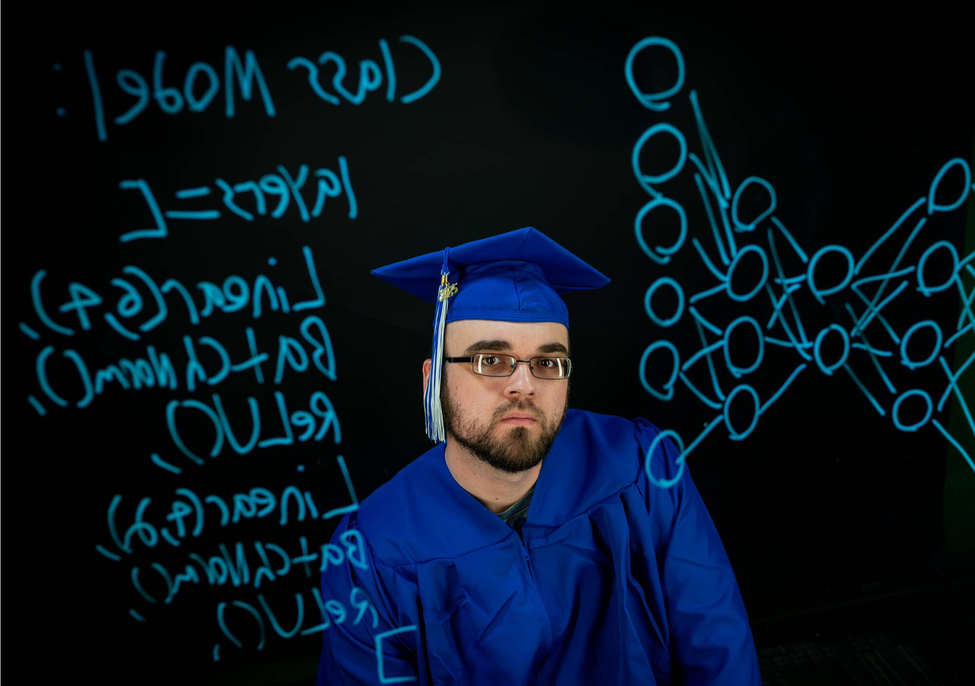 Computer Science major Anthony Boos is pictured with the Bridge Studio lightboard at the Kindschi Hall of Science on March 24. On the lightboard is a drawing of a neural network.
